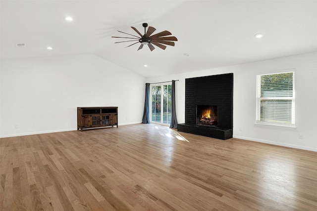 unfurnished living room with ceiling fan, light hardwood / wood-style floors, a fireplace, and vaulted ceiling