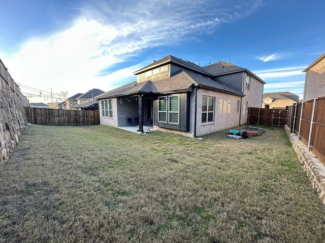 back of house featuring a patio area and a lawn