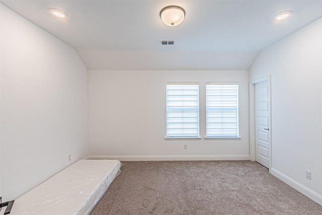 unfurnished bedroom featuring carpet flooring, a closet, and vaulted ceiling