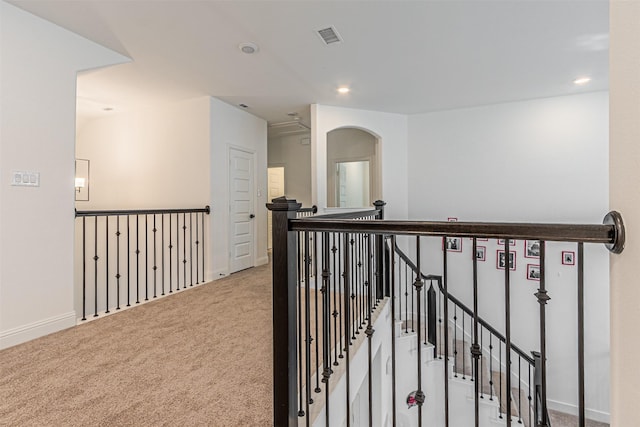 hallway featuring light colored carpet