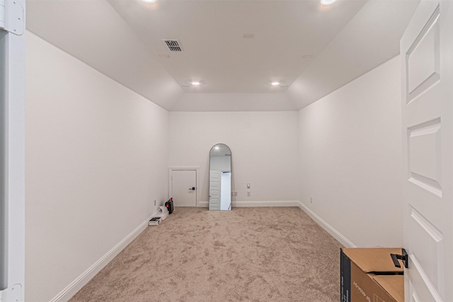 unfurnished room with vaulted ceiling and light colored carpet