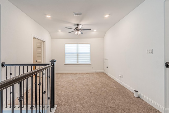 spare room featuring vaulted ceiling, carpet, and ceiling fan