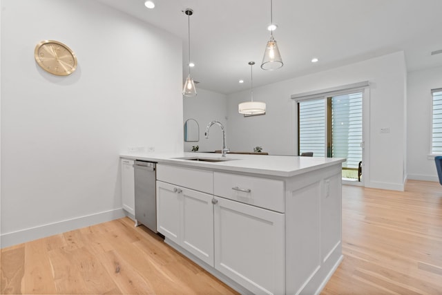 kitchen featuring white cabinetry, decorative light fixtures, light hardwood / wood-style floors, and sink