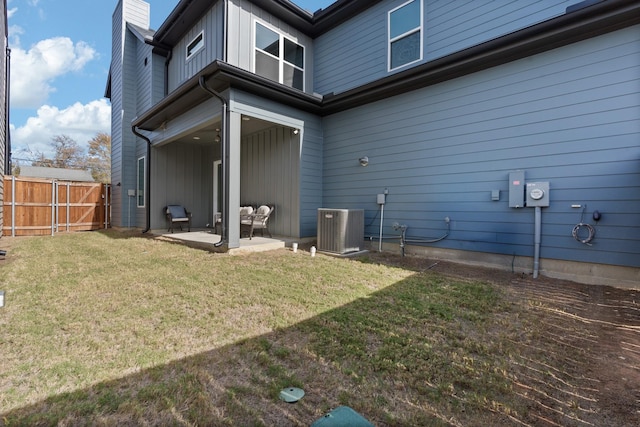 back of house with central AC unit, a yard, and a patio