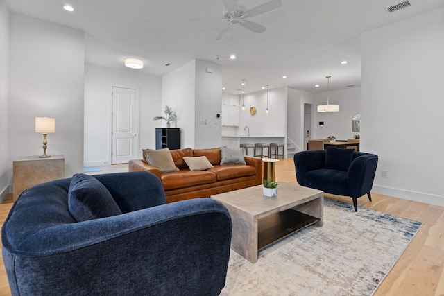 living room featuring ceiling fan and light wood-type flooring