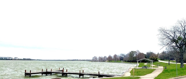 dock area with a water view and a lawn