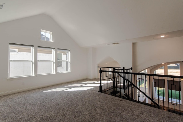 empty room featuring carpet floors and high vaulted ceiling