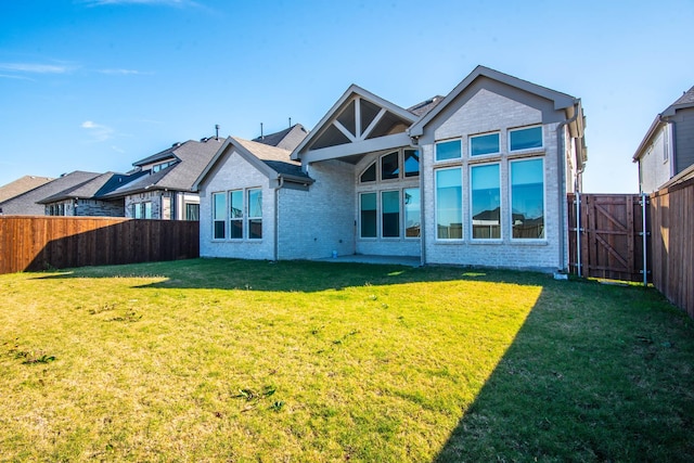 rear view of house featuring a lawn