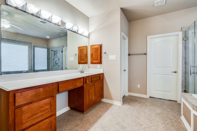 bathroom featuring a shower with shower door and vanity