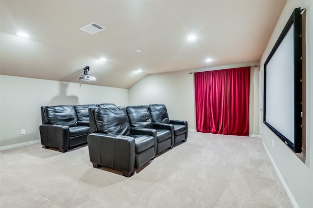 cinema room featuring light carpet and vaulted ceiling