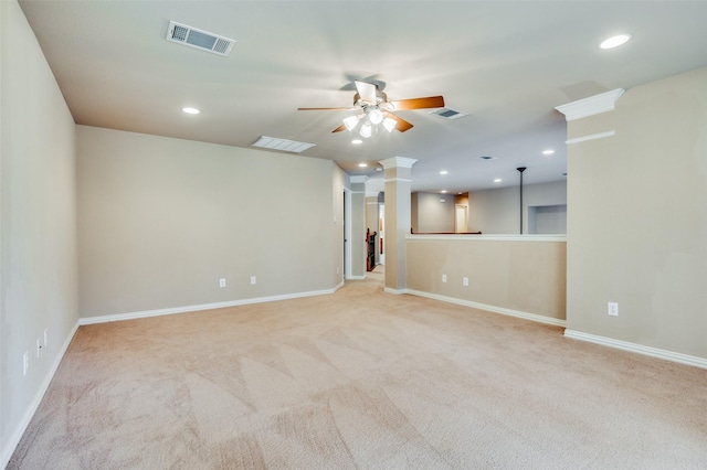 empty room featuring ceiling fan, light carpet, and ornate columns