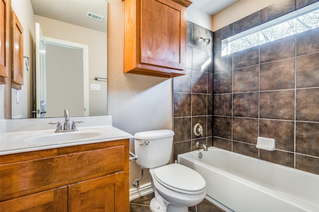 full bathroom featuring tile patterned floors, toilet, vanity, and tiled shower / bath combo