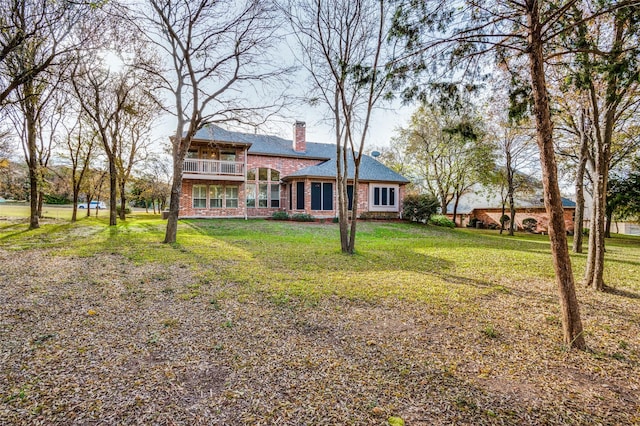 exterior space with a balcony and a yard