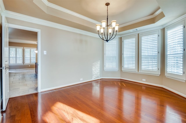 unfurnished room with a wealth of natural light, a tray ceiling, and crown molding