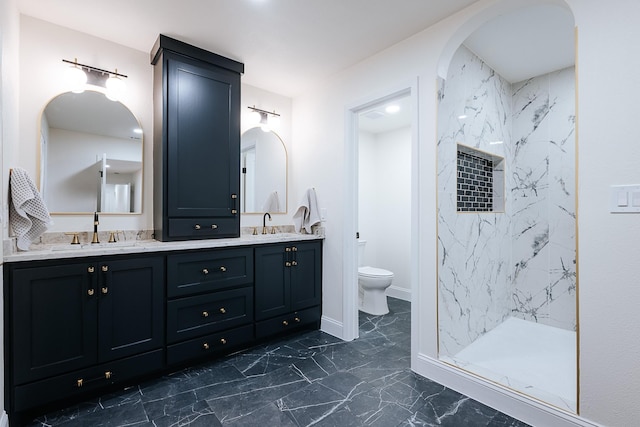 bathroom featuring tiled shower, vanity, and toilet