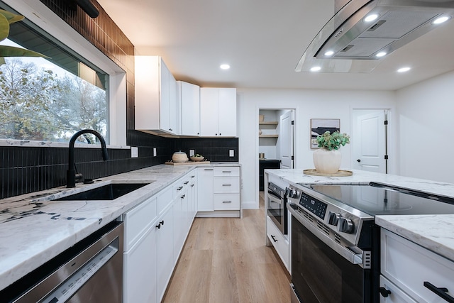 kitchen featuring stainless steel appliances, sink, white cabinetry, light stone counters, and light wood-type flooring