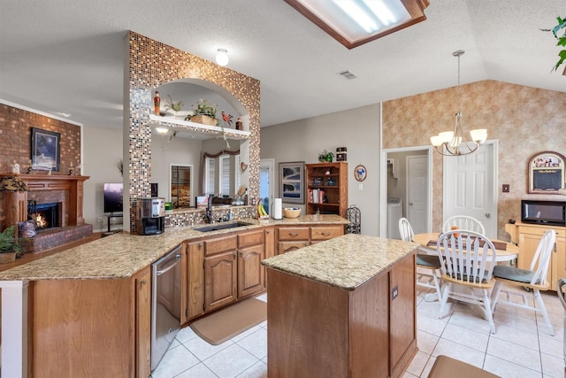 kitchen featuring sink, stainless steel dishwasher, kitchen peninsula, vaulted ceiling, and light tile patterned floors