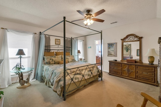 carpeted bedroom with a textured ceiling and ceiling fan