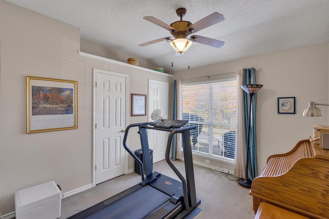 workout room featuring carpet flooring, ceiling fan, a textured ceiling, and a wealth of natural light