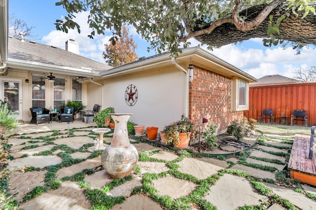 view of side of property with ceiling fan and a patio area