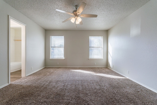 carpeted spare room with ceiling fan and a textured ceiling