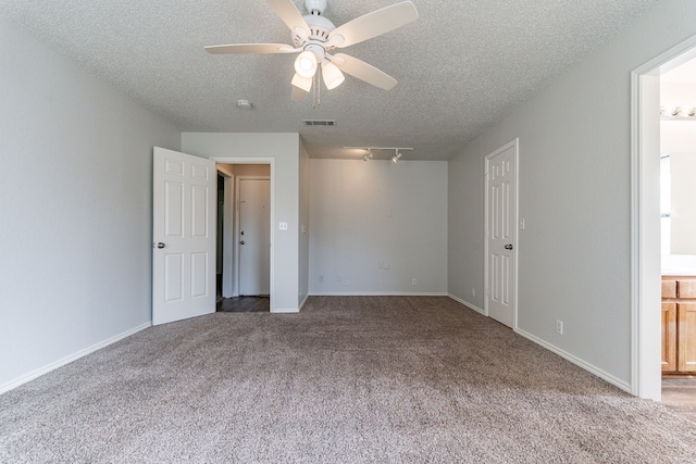 unfurnished bedroom with ceiling fan, carpet floors, a textured ceiling, and ensuite bath