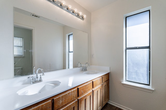 bathroom featuring vanity, toilet, and a wealth of natural light