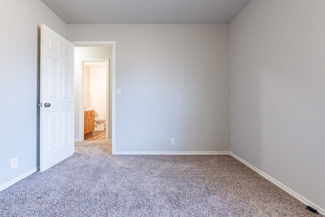 carpeted empty room with a textured ceiling