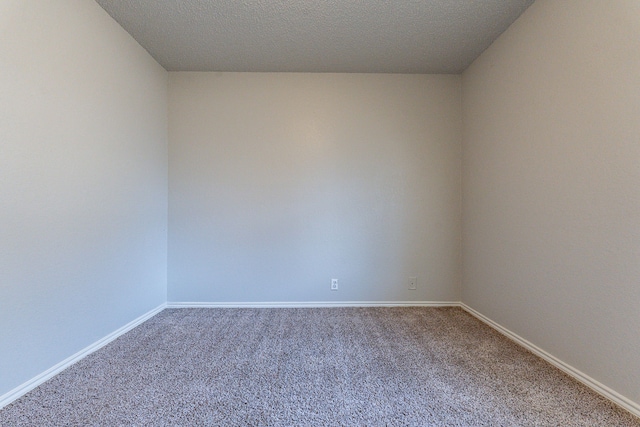 empty room with carpet flooring and a textured ceiling