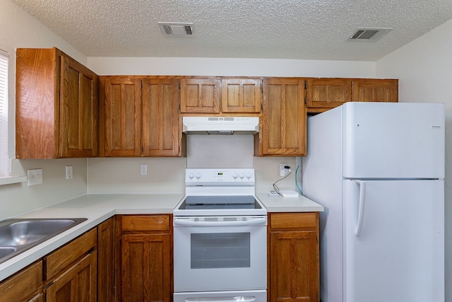 kitchen with sink, white appliances, and a textured ceiling