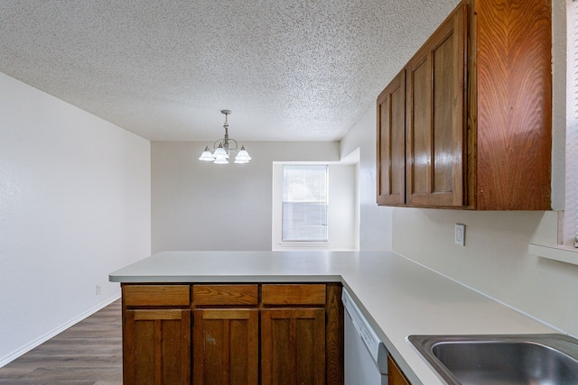 kitchen featuring kitchen peninsula, white dishwasher, decorative light fixtures, a chandelier, and dark hardwood / wood-style floors