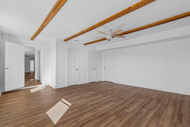 unfurnished living room with ceiling fan, beam ceiling, and dark hardwood / wood-style flooring