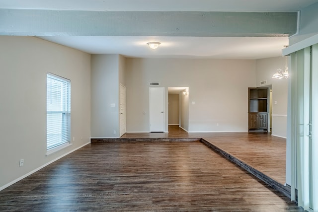 spare room featuring a chandelier and dark hardwood / wood-style floors