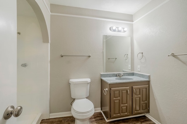 bathroom featuring hardwood / wood-style floors, vanity, toilet, and a shower