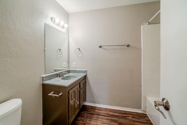 full bathroom with hardwood / wood-style floors, vanity, toilet, and bathing tub / shower combination