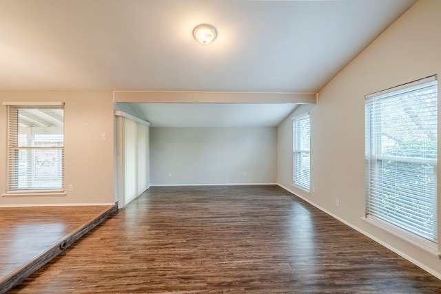 unfurnished living room with lofted ceiling with beams and dark wood-type flooring