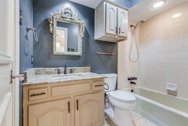 full bathroom with tile patterned flooring, vanity, tiled shower / bath combo, and toilet