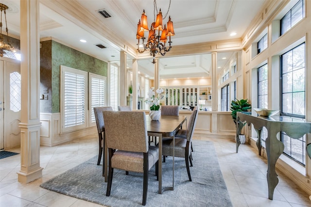 tiled dining space with decorative columns, a raised ceiling, a wealth of natural light, and a notable chandelier