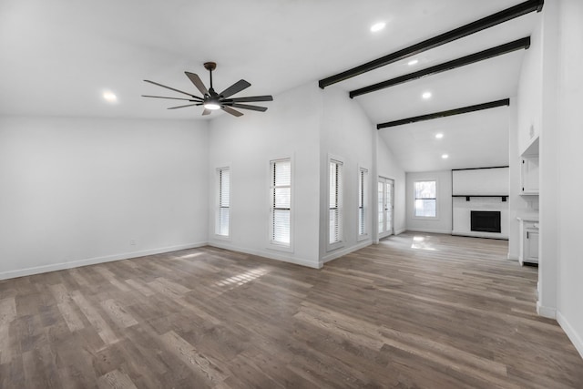 unfurnished living room featuring a large fireplace, baseboards, wood finished floors, and beamed ceiling