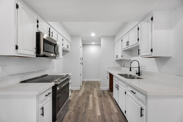 kitchen featuring sink, white cabinets, hardwood / wood-style floors, and appliances with stainless steel finishes