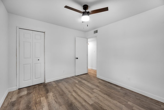 unfurnished bedroom featuring hardwood / wood-style flooring, ceiling fan, and a closet