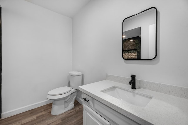 bathroom featuring wood-type flooring, vanity, and toilet