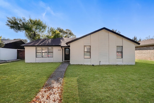 view of front of property featuring brick siding, a front yard, and fence