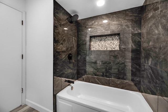 bathroom featuring hardwood / wood-style floors and tiled shower / bath