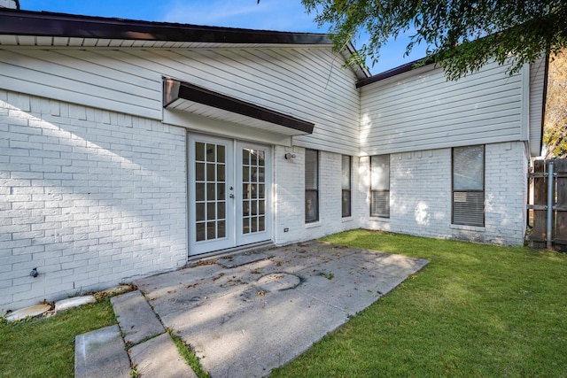 rear view of property featuring a yard, french doors, and a patio