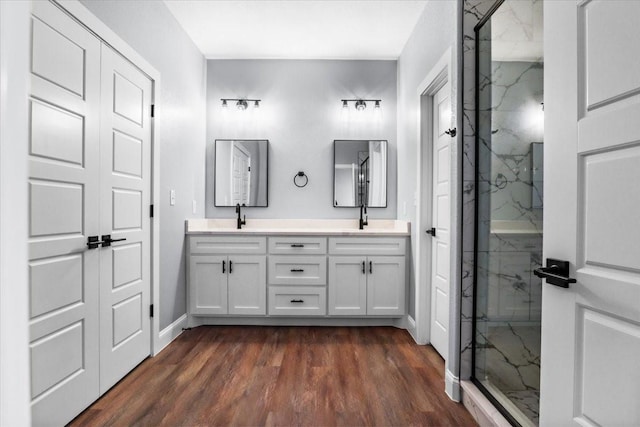 bathroom with hardwood / wood-style flooring, vanity, and a shower with door