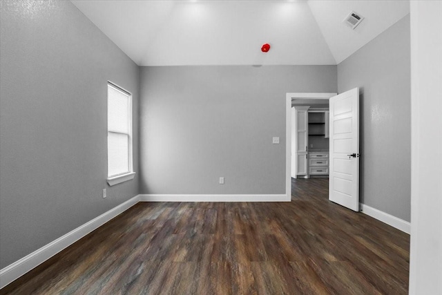 unfurnished bedroom featuring vaulted ceiling and dark hardwood / wood-style floors