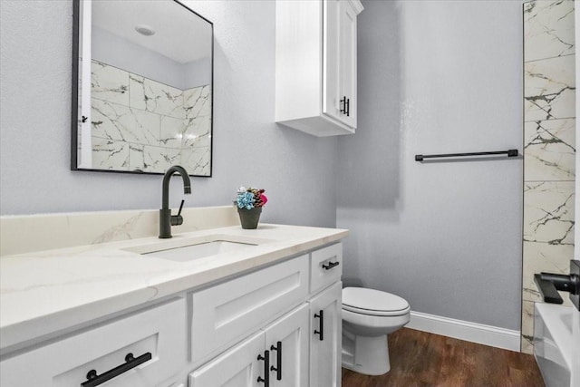 bathroom with hardwood / wood-style flooring, vanity, and toilet