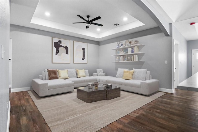 living room with a raised ceiling, ceiling fan, and hardwood / wood-style floors