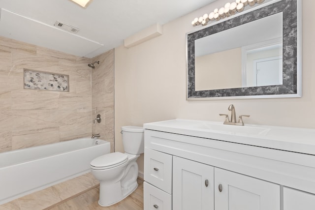 full bathroom with vanity, tiled shower / bath combo, and toilet